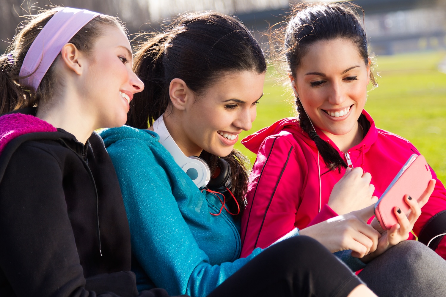 Friends having fun with smartphones after exercise